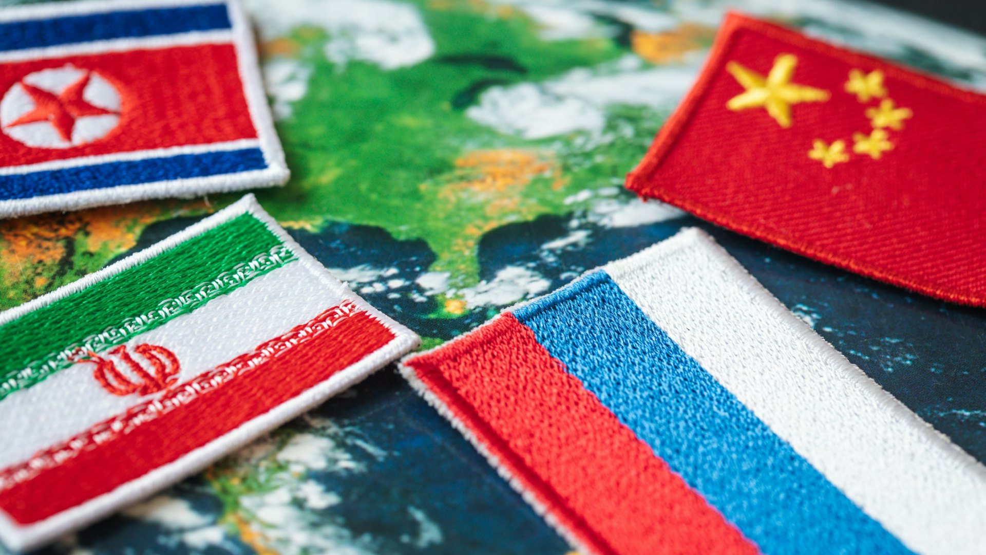 North Korea, China, Russia, and Iranian flags on top of a map.