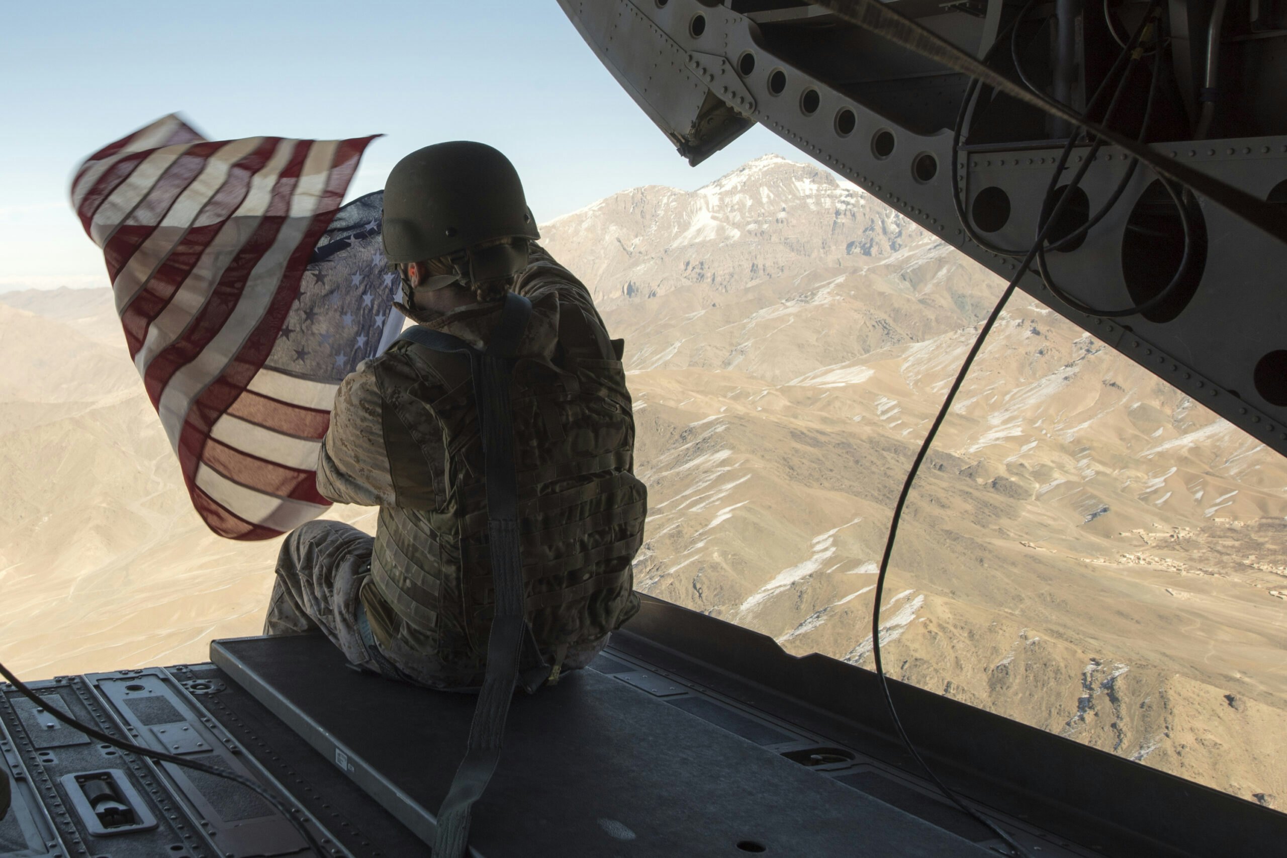 Marine Corps Capt. Kimberly Sonntag holds the American flag out the back of a CH-47 Chinook Helicopter as it moves to Operating Base Fenty, Dec. 24, 2017. Dunford and Troxell, along with USO entertainers, visited service members who are deployed during the holidays. This year’s entertainers are Chef Robert Irvine, wrestler Gail Kim, comedian Iliza Shlesinger, actor Adam Devine, country musician Jerrod Niemann, and WWE Superstars “The Miz” and Alicia Fox. (DoD photo by Navy Petty Officer 1st Class Dominique A. Pineiro/Released)